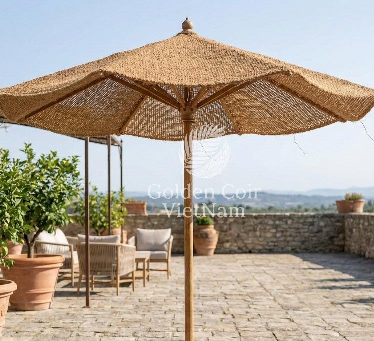 Natural coir parasol with wooden center pole providing decorative sun shade in a Mediterranean style outdoor patio