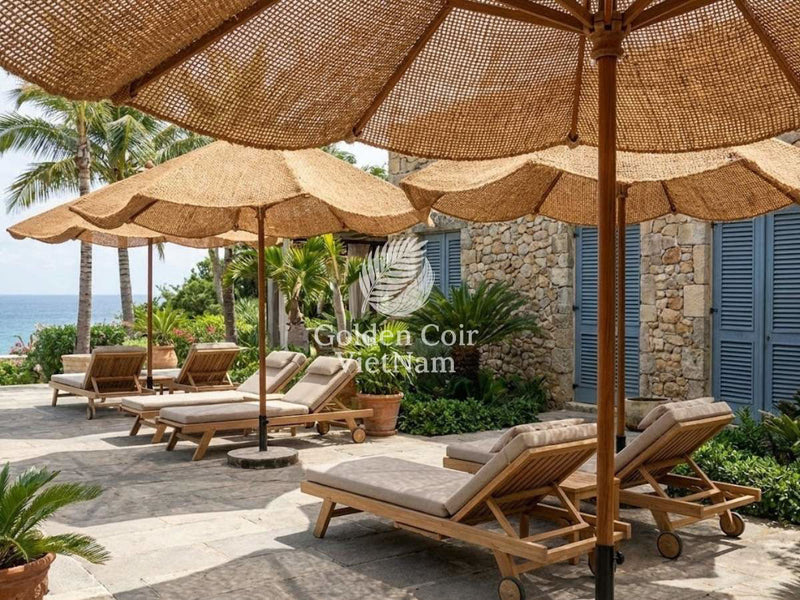 Natural coir commercial parasols shading sun loungers at a seaside resort terrace with ocean view