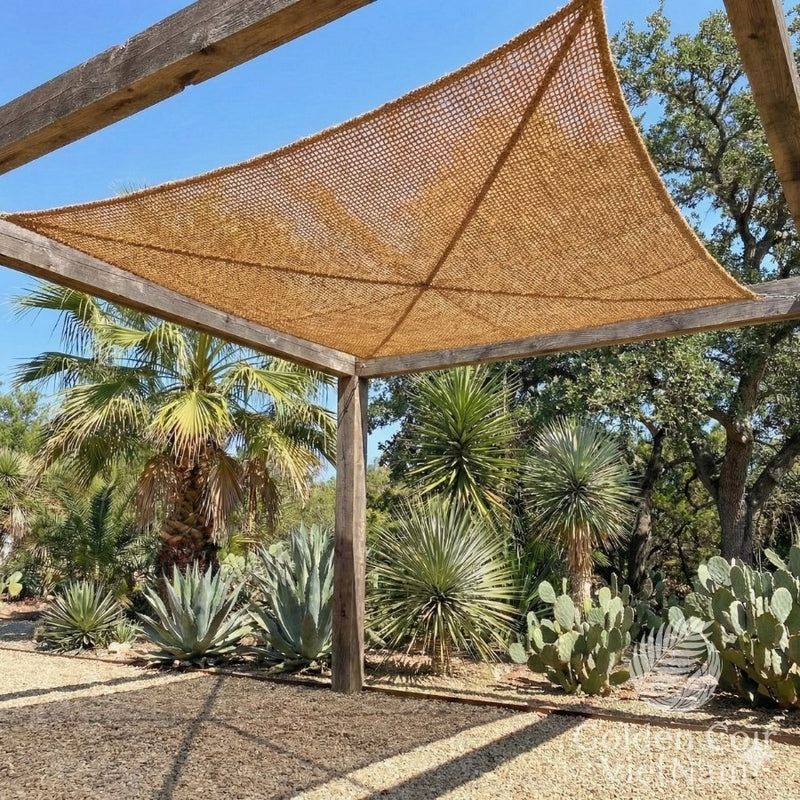Wooden pergola with a woven canopy in a garden setting with cacti and palm trees.